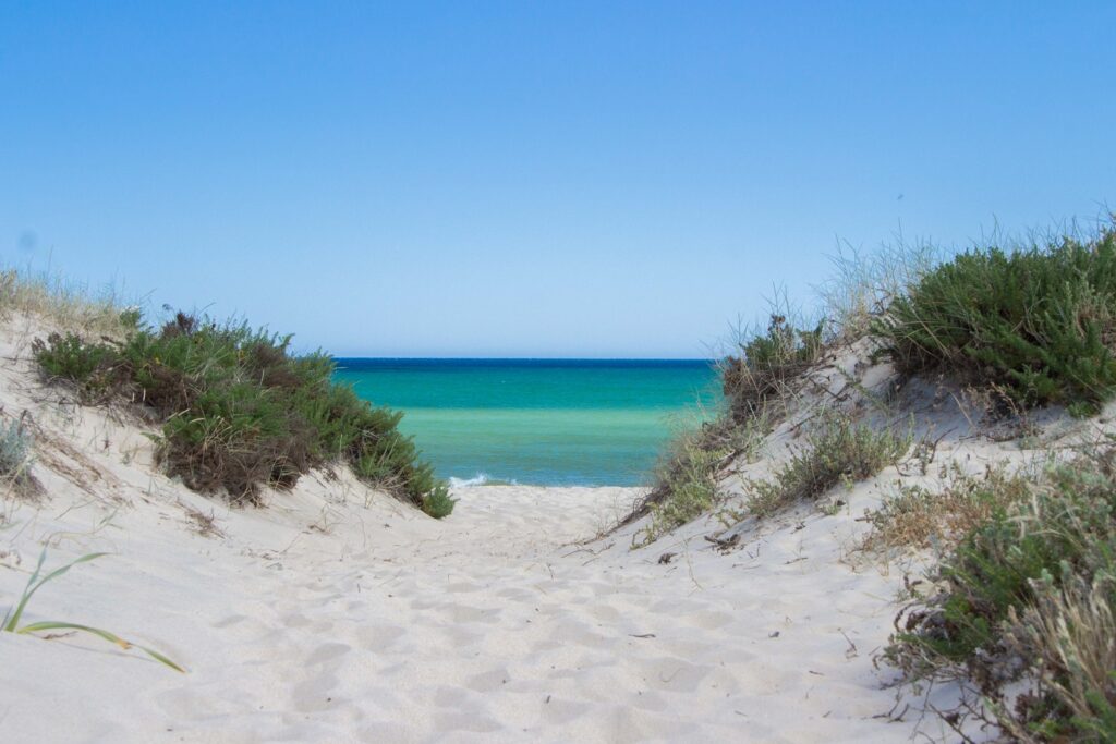 Paysage paradisiaque de bord de mer avec un sable blanc et une eau turquoise au Portugal