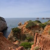 Paysage de la région portugaise de l'Algarve avec la mer en fond et des falaises aux couleurs orangées de part et d'autre