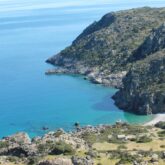 Paysage du bord de mer de Crète avec de l'eau turquoise en contrebas, encadré de montagnes
