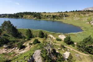 Lac de montagne entouré de végétation mais aussi de roches
