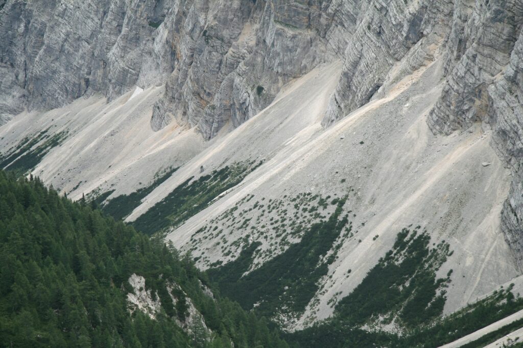 Paysage du massif des Karavanes en Slovénie avec des montagnes rocheuses et rocailleuses, et en bas de ces dernières de la végétation et des forêts