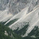 Paysage du massif des Karavanes en Slovénie avec des montagnes rocheuses et rocailleuses, et en bas de ces dernières de la végétation et des forêts