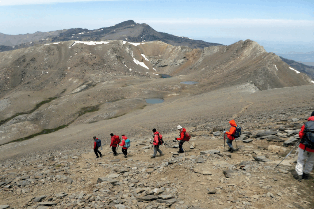groupe de randonneurs en train de descendre une montagne dans le parc naturel de la Sierra Nevada