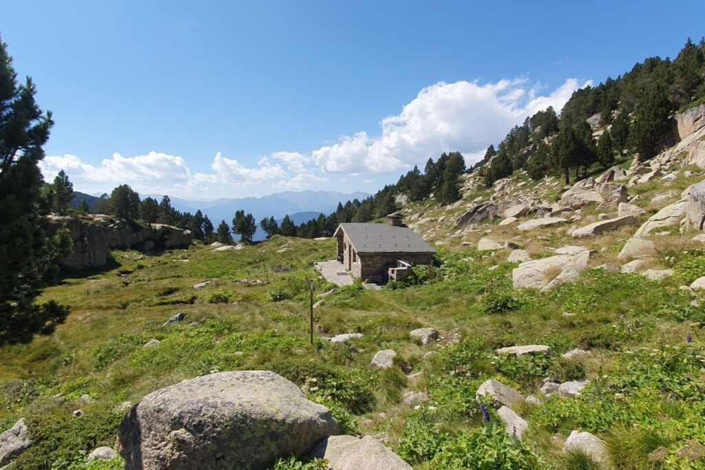 Paysage de montagne en Andorre avec une maison de berger en pierre.