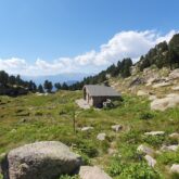 Paysage de montagne en Andorre avec une maison de berger en pierre.
