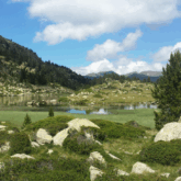 Paysage montagnard verdoyant avec un lac en arrière-plan, paysage andorran. Cette photo a été prise lors d'une randonnée en Andorre.