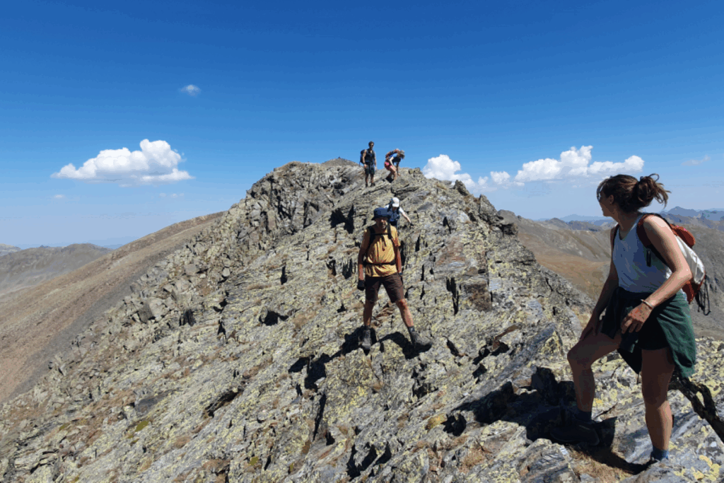 Groupe de randonneurs en train de marcher sur une crête rocheuse en Andorre.