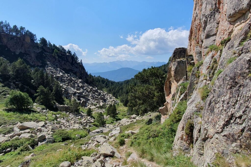 paysage de montagne où l'on voit à la fois l'herbe verte et des parois de falaises rocheuses
