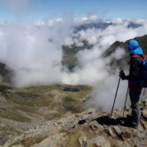 Randonneur qui observe le point de vue au cours de sa randonnée en haut d'un sommet
