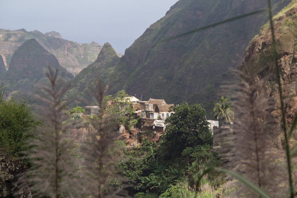 Paysage vallonné avec des sommets en fond et un village typique du Cap-Vert au centre