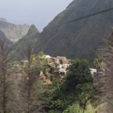 Paysage vallonné avec des sommets en fond et un village typique du Cap-Vert au centre