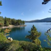 Lac de montagne observé depuis les berges, qui donne une vue sur la montagne et le paysage à côté