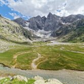 Paysage montagnard estival avec des sommets enneigés en fond