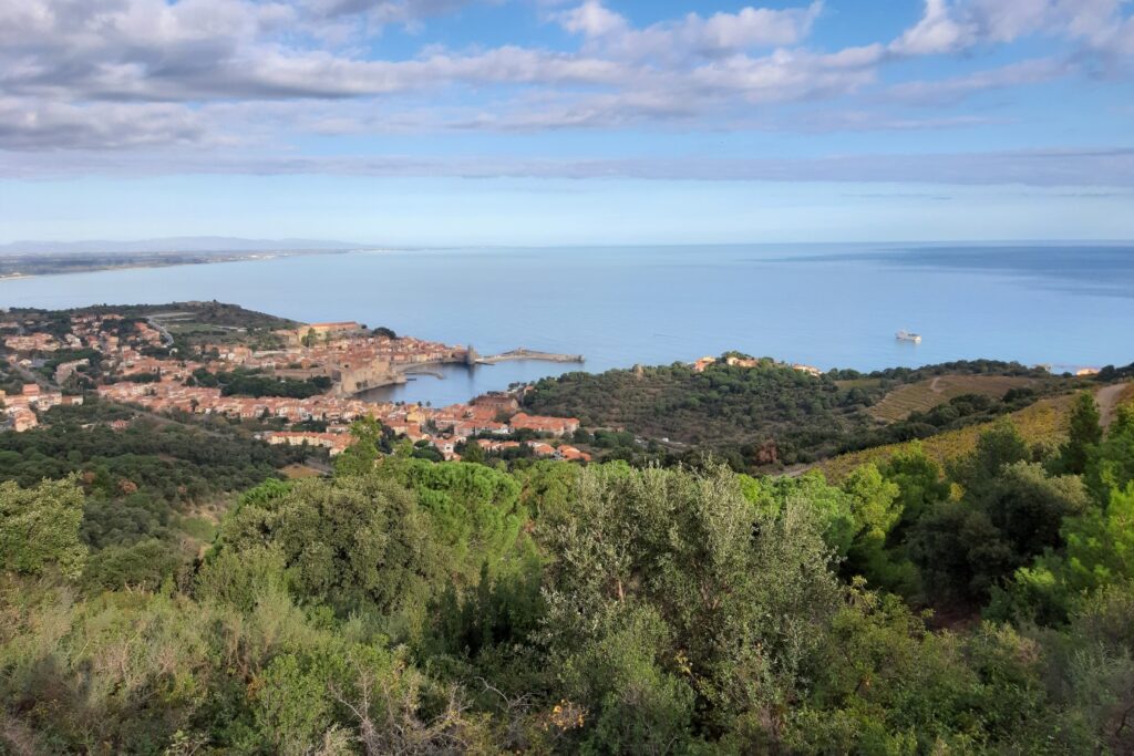 Vue entre mer et montagne, avec en contrebas la baie et un village.