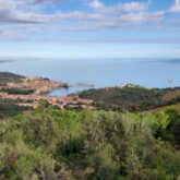 Vue entre mer et montagne, avec en contrebas la baie et un village.