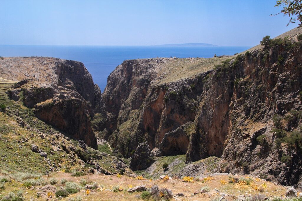 Paysage entre mer et montagne, avec au premier plan des montagnes et des falaises, avec au loin la mer, en Crète
