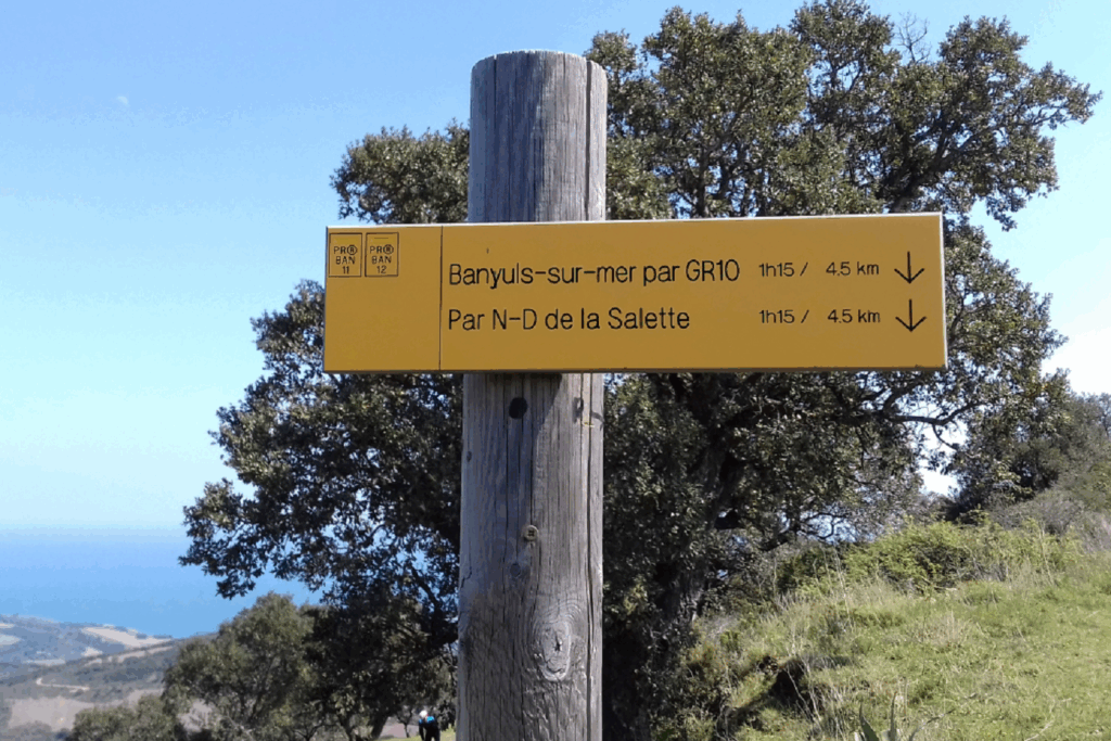 Paysage montagnard avec un panneau indiquant les différents sentiers possibles sur le trajet du GR10