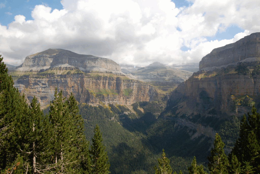 Paysage avec au premier plan des arbres et à l'arrière des sommets, paysage qui s'observe lors du séjour reliant Gavarnie et Ordesa