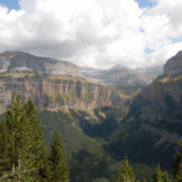 Paysage avec au premier plan des arbres et à l'arrière des sommets, paysage qui s'observe lors du séjour reliant Gavarnie et Ordesa