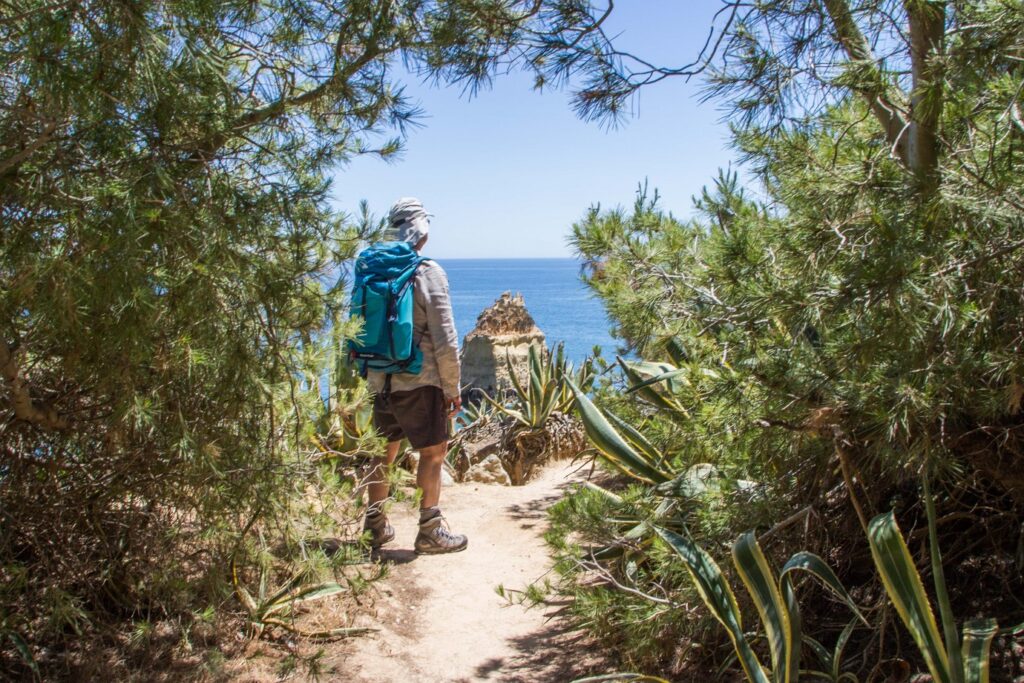 Groupe de randonneurs sur un sentier, au Portugal, encadré de végétation et de flore diverse
