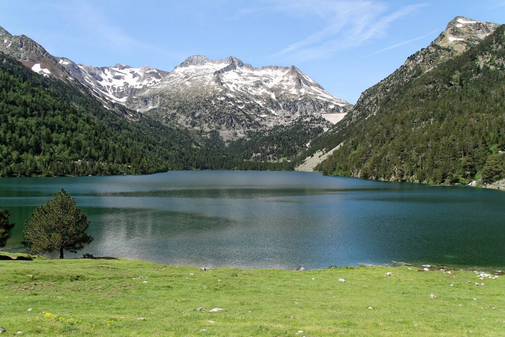 Lac de montagne et sommets à l'arrière-plan avec à l'avant une prairie