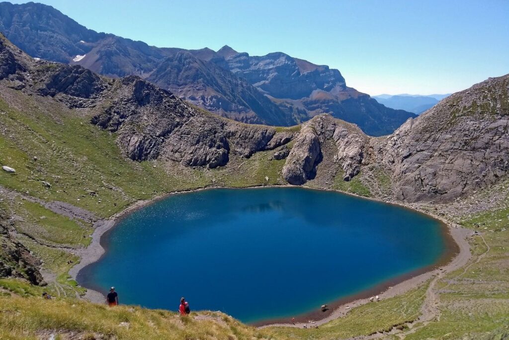 Paysage d'un lac de montagne en été au soleil avec deux montagnards au bord