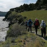 Groupe de randonneurs sur un chemin de randonnées côtier qui suivent leur guide lors d'un séjour de marche nordique avec un guide