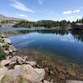 Berges d'un lac avec en fond une forêt et des sommets
