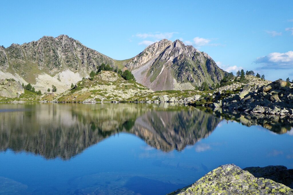 Paysage de montagne avec, au premier plan, un lac et des sommets dans le fond.
