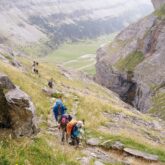 Groupes de randonneurs sur un sentier avec leur guide sur la haute randonnée pyrénéenne entre le Vignemale et les Posets