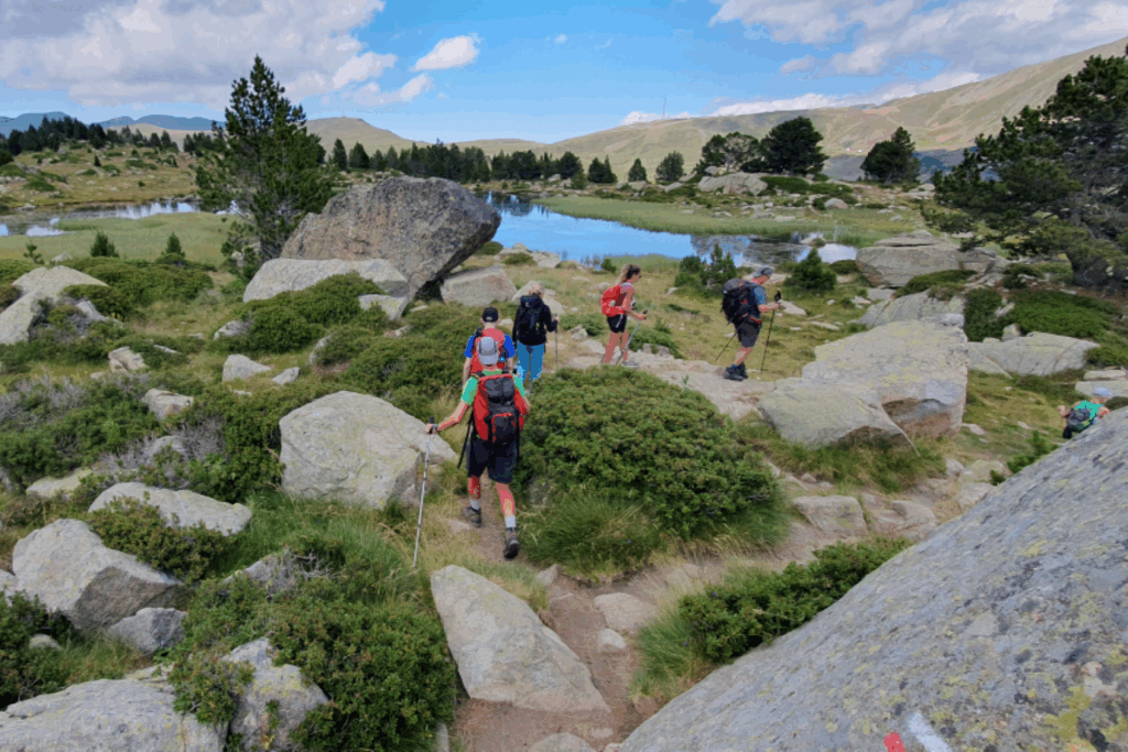 Groupe de randonneurs se dirigeant vers un lac de montagne en andorre