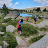 Groupe de randonneurs se dirigeant vers un lac de montagne en andorre