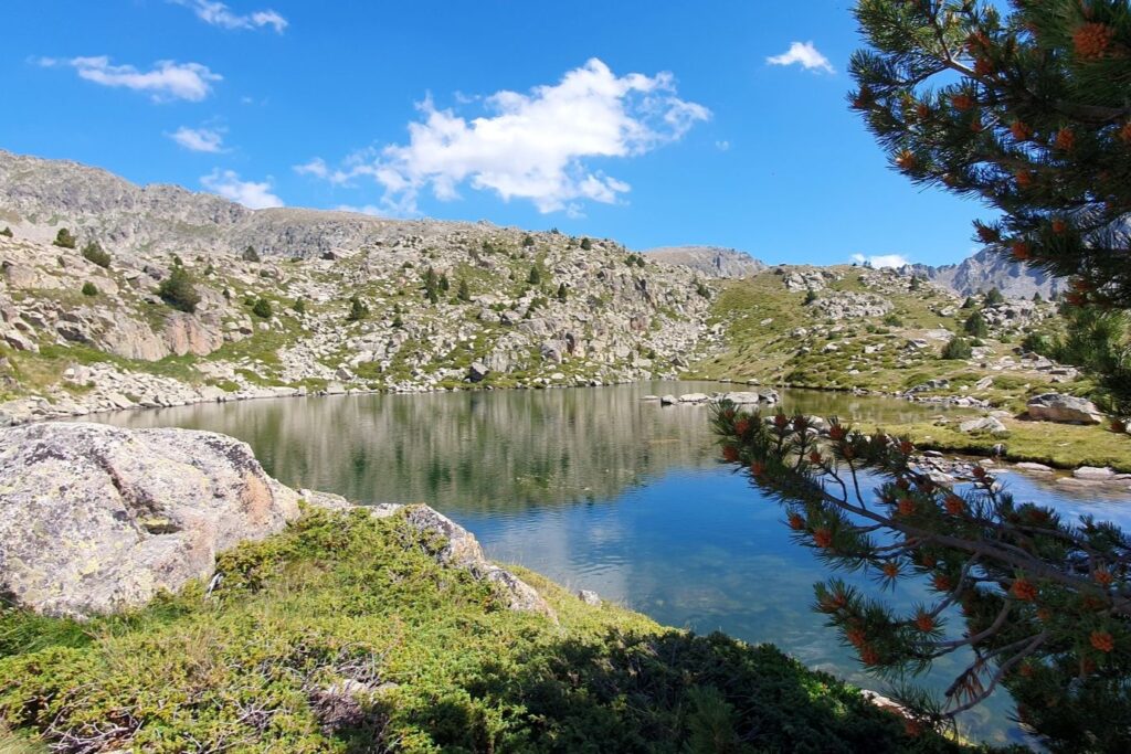 Lac de montagne en Andorre, avec un paysage ensoleillé.