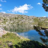Lac de montagne en Andorre, avec un paysage ensoleillé.