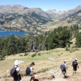 groupe de randonneurs sur un sentier avec leur guide en train de descendre un pan de la montagne