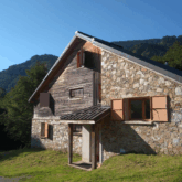 Photo d'une maison en pierre et en bois moderne, dans la montagne