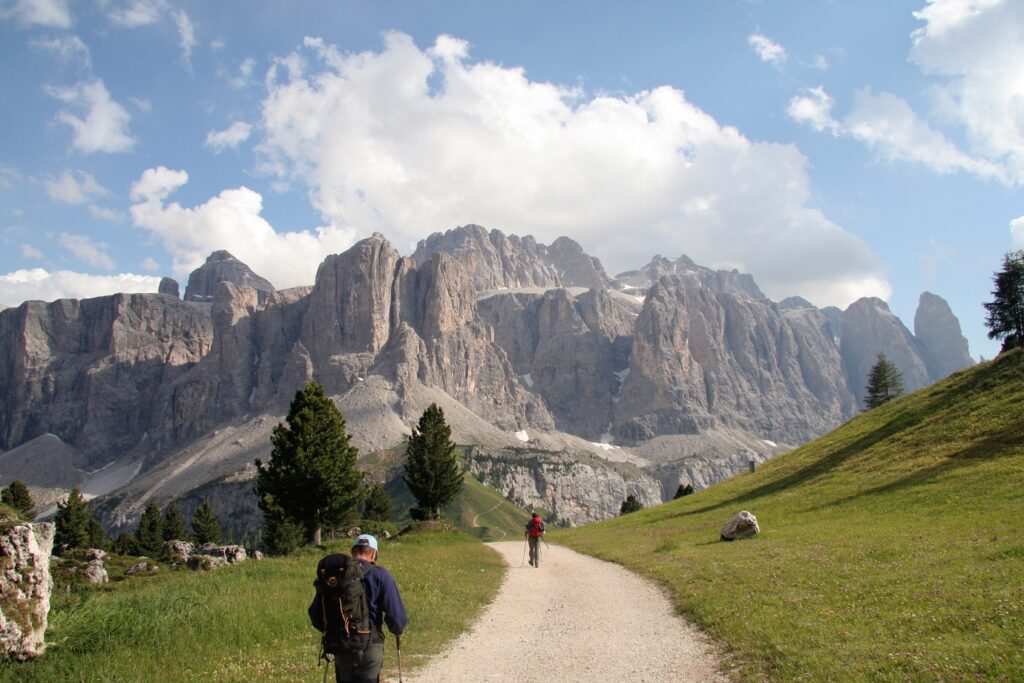 Randonneurs sur un sentier de montagnes dans les dolomites, avec face à lui un sommet