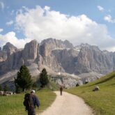 Randonneurs sur un sentier de montagnes dans les dolomites, avec face à lui un sommet