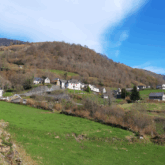Paysage du Pays Basque avec un petit village en contrebas surplombé par un sommet et une forêt