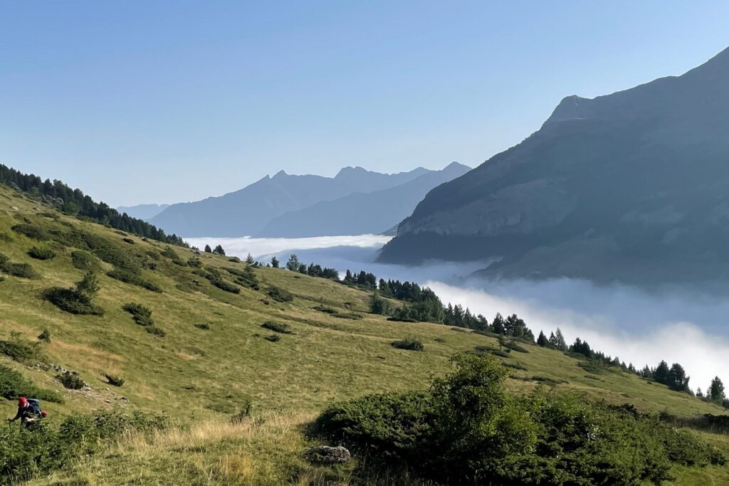 Paysage estival avec une mer de nuages en fond qui couvre la vallée