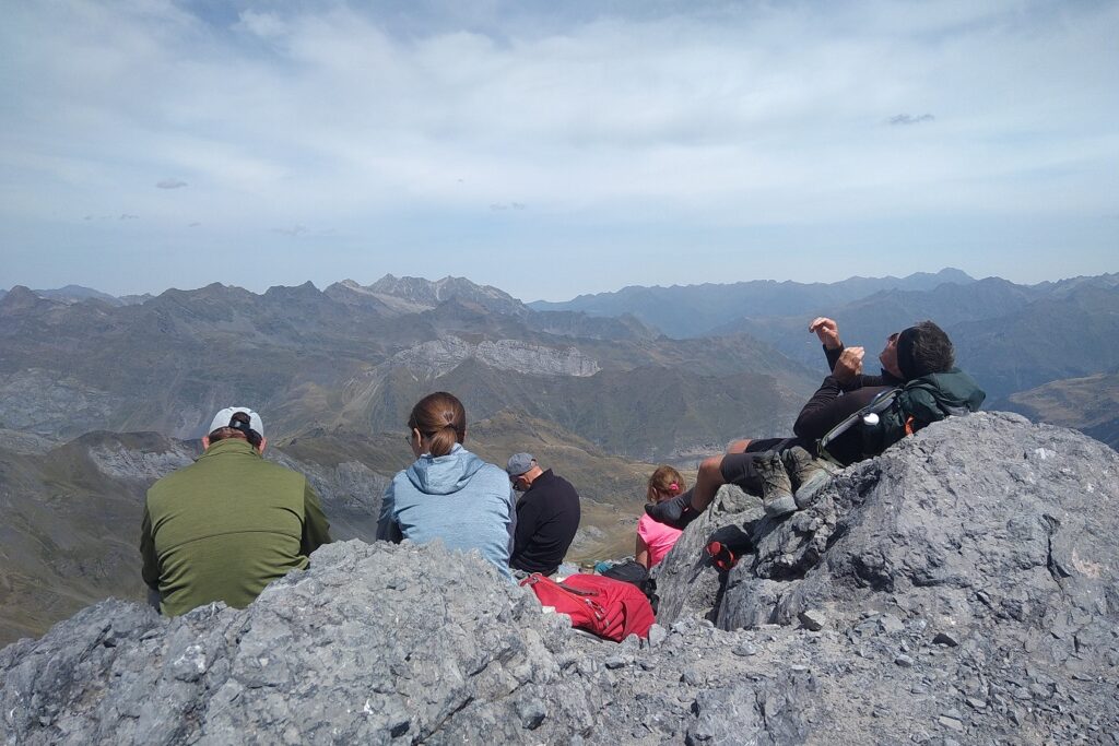 Groupe de randonneurs face à la vue au sommet d'une montagne