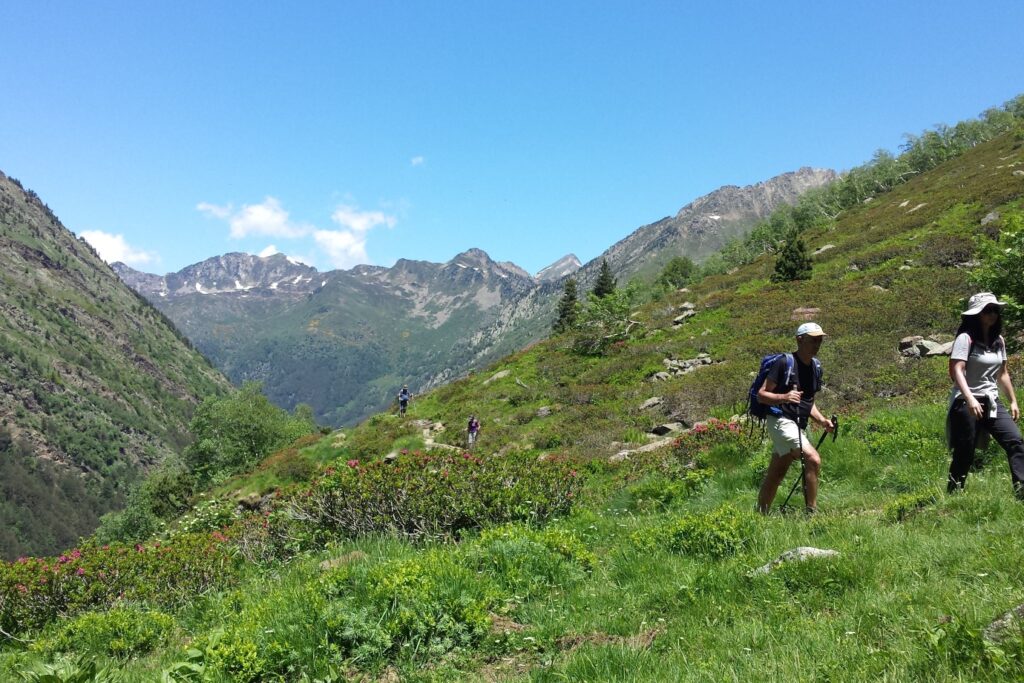 Paysage de randonneurs en train de randonner et de monter sur une montagne au cours d'une randonnée accompagnée par un guide en Ariège authentique