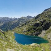 Paysage de montagne avec un lac entouré de montagnes et d'une prairie verdoyante