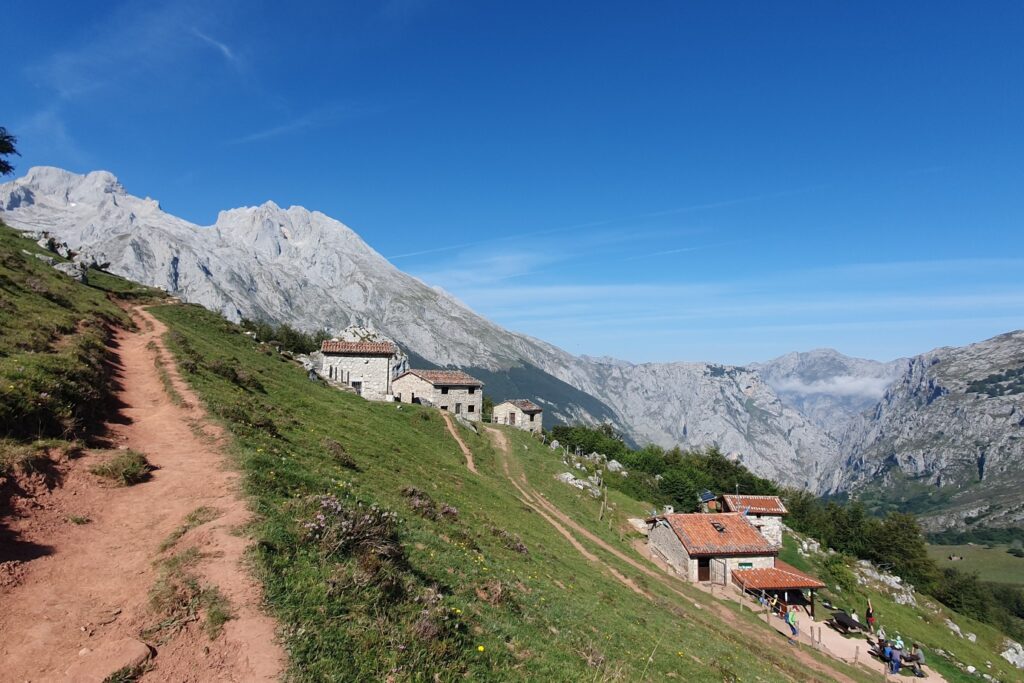 Chemin de terre rouge avec en fond des sommets