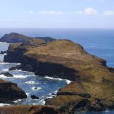 Paysage sur l'île de Madère qui mélange à la fois terre et océan avec une langue de montagne qui s'éloigne de la côte, encadrée de chaque côté par l'océan