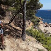 Groupe de randonneurs en Costa Brava sur un sentier côtier à l'ombre des arbres