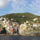 Prise de vue depuis la mer d'un village perché et coloré dans les cinq terres