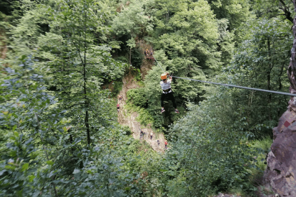 Paysage montagnard et forestier avec un groupe de famille qui fait de l'accrobranche