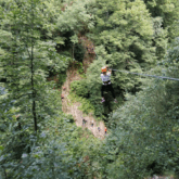 Paysage montagnard et forestier avec un groupe de famille qui fait de l'accrobranche