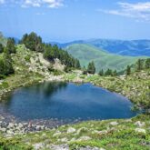 Paysage de montagne, lac et forêts avec des sommets au loin